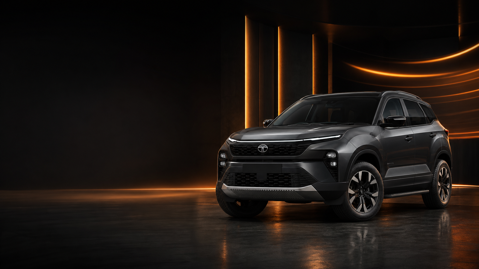 A graphite Tata SUV in a premium amber studio